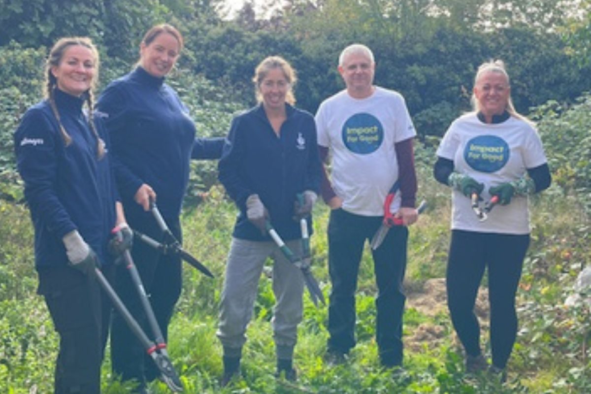 Allwyn volunteers with gardening tools participating in a Green aiders session in someone's overgrown back garden