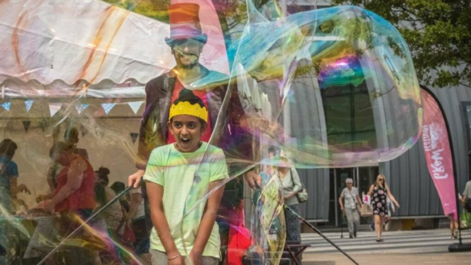 Report cover image: a young boy is entertained by a street performer blowing bubbles