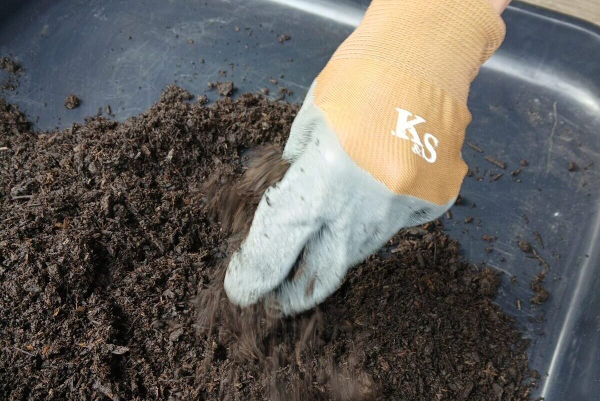 Close up of a hand sifting soil